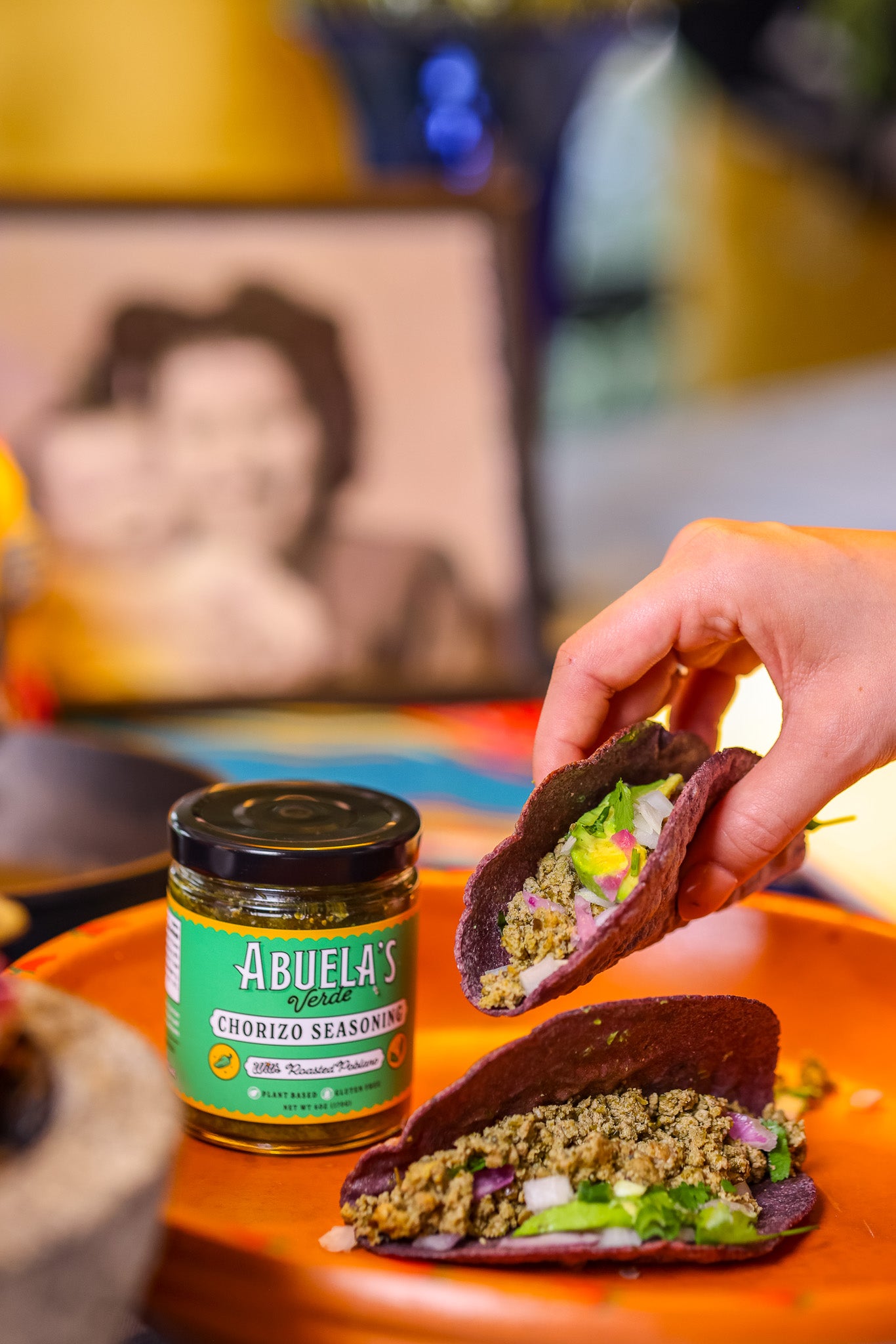 Abuela's Verde Chorizo Seasoning Jar with Hand Holding Tacos