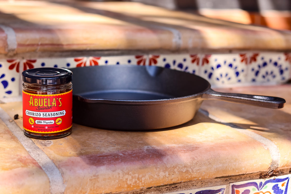 Spanish chorizo seasoning jar with a cast iron skillet on a terracotta ledge in front of Talavera tile