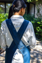 Back view of the Blue cross-back linen apron with the HSF butterfly embroidery on the strap
