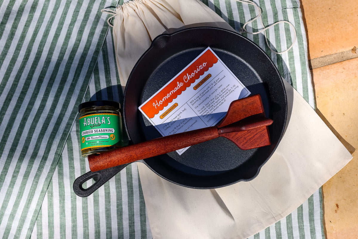 Chorizo kit skillet resting on the cream cotton dust bag it ships in, with Verde seasoning and teak chopper