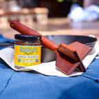 Original chorizo seasoning jar beside the teak chopper and cast iron skillet on a blue apron
