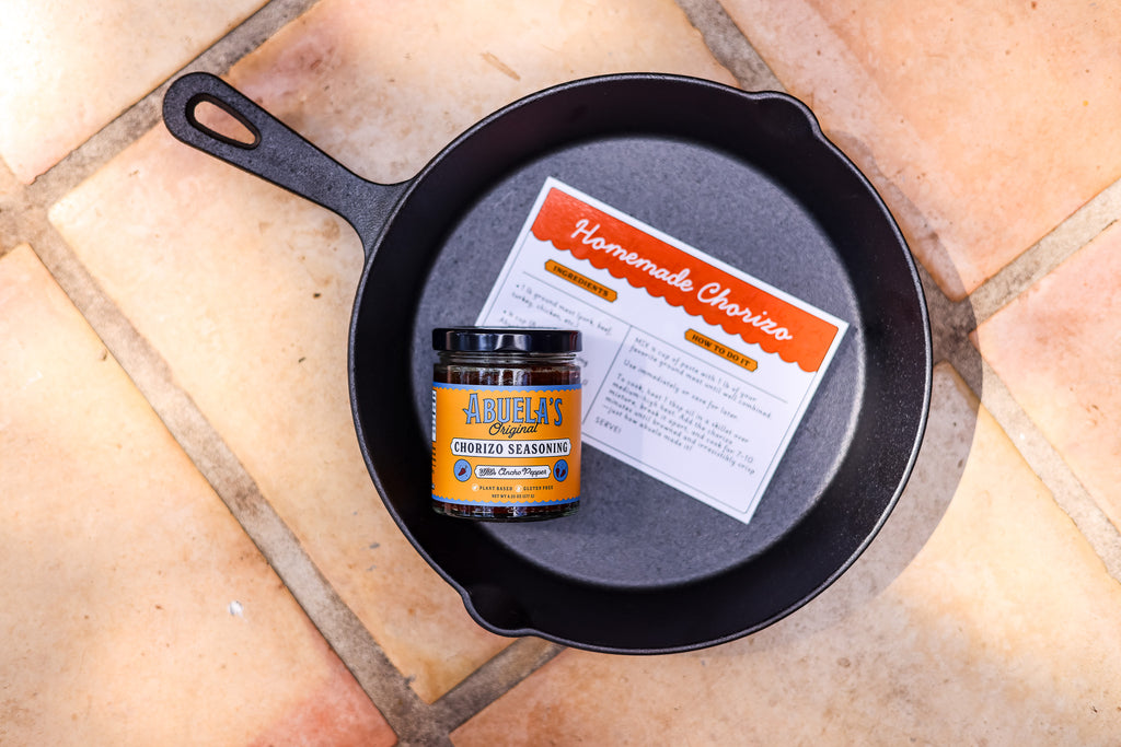 Overhead view of a cast iron skillet holding the recipe card and Original chorizo seasoning
