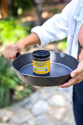 Model holding the Hess Street cast iron skillet with a jar of Original chorizo seasoning inside