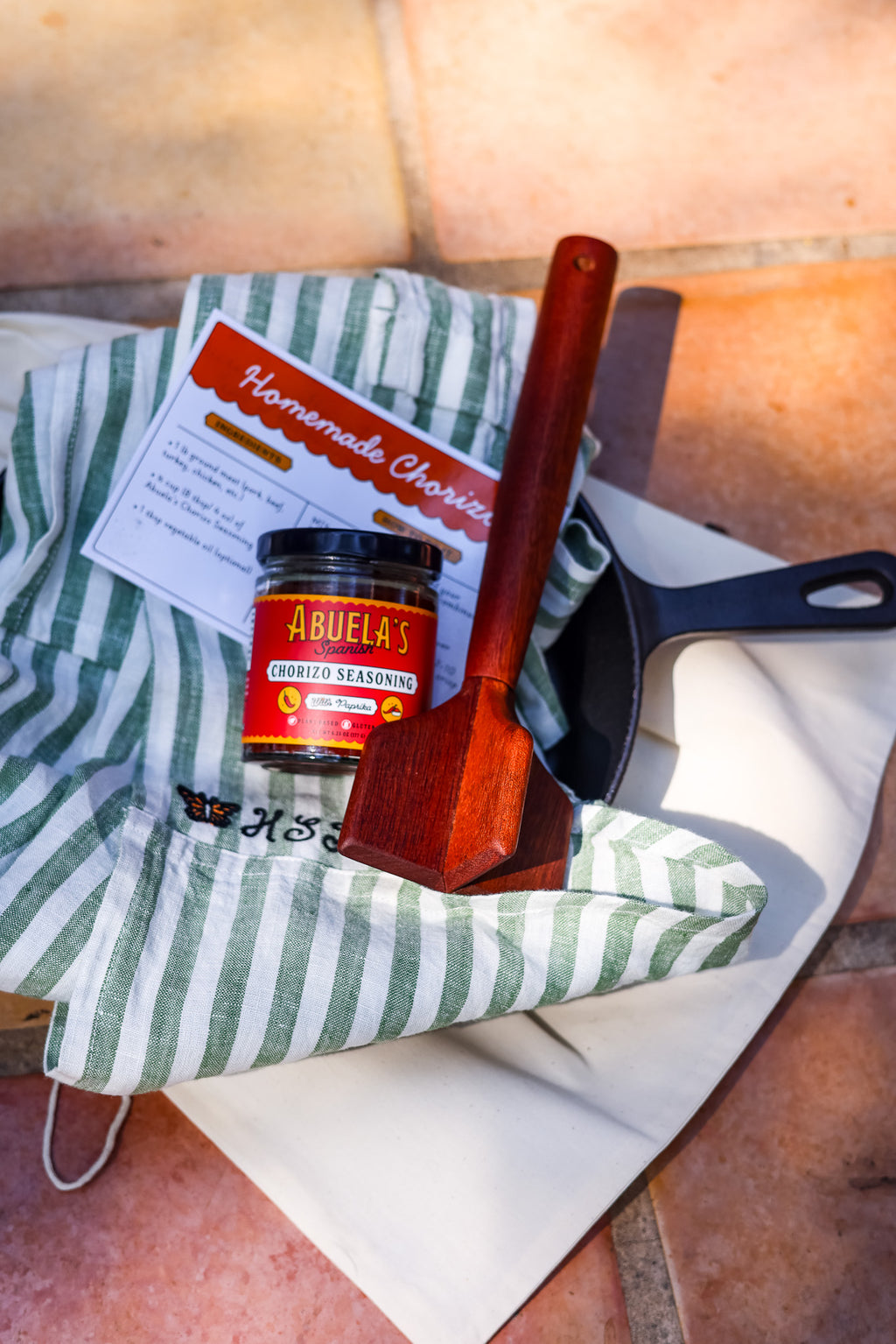 Chorizo gift bundle with Spanish seasoning, skillet, teak chopper and Green Stripe apron in a cotton dust bag